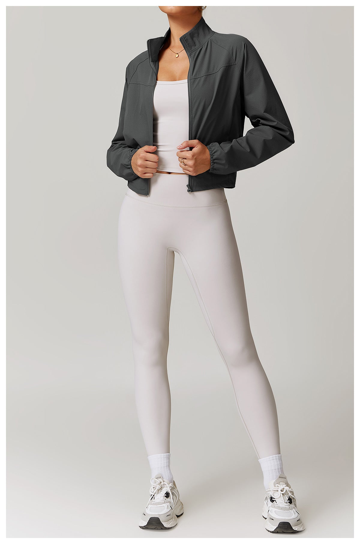 Athletic outfit with dark bomber jacket and light gray leggings, perfect for active fashion