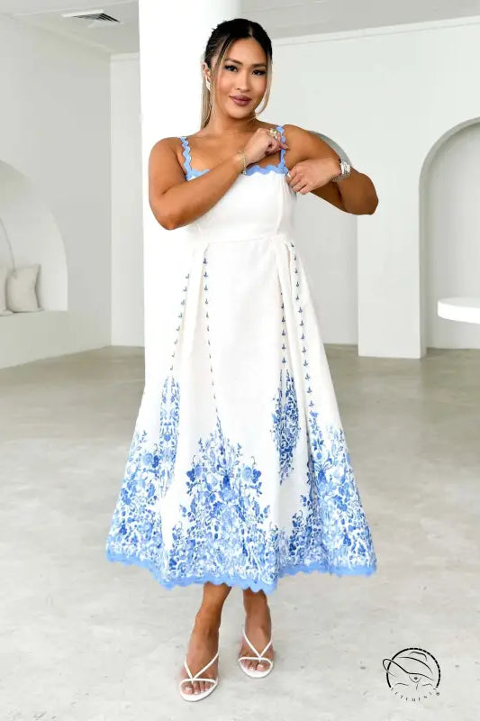 Attractive backless dress in white with blue floral embroidery on hem and straps