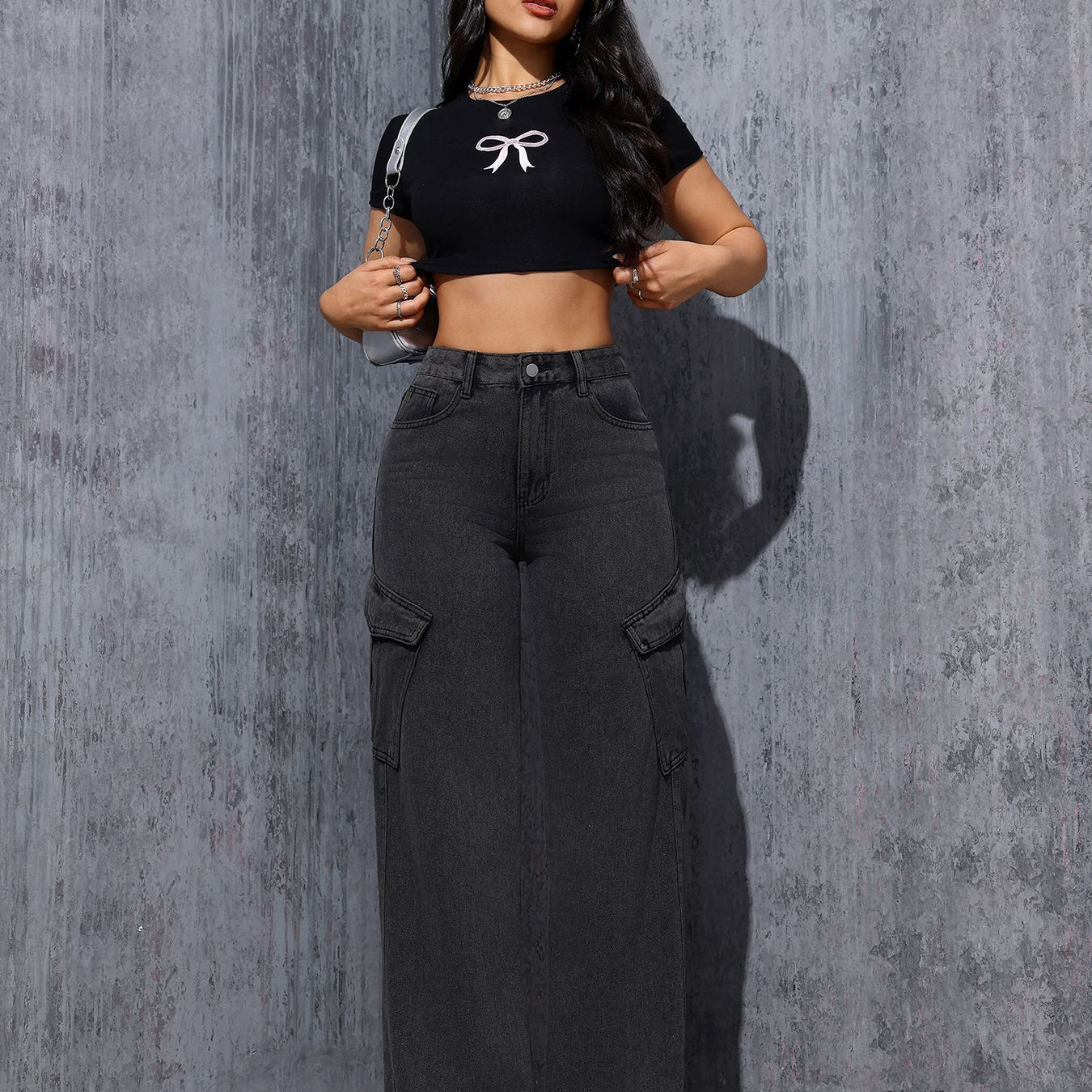 Woman in black crop top and wide-leg cargo jeans showcasing trendy gray black fashion style