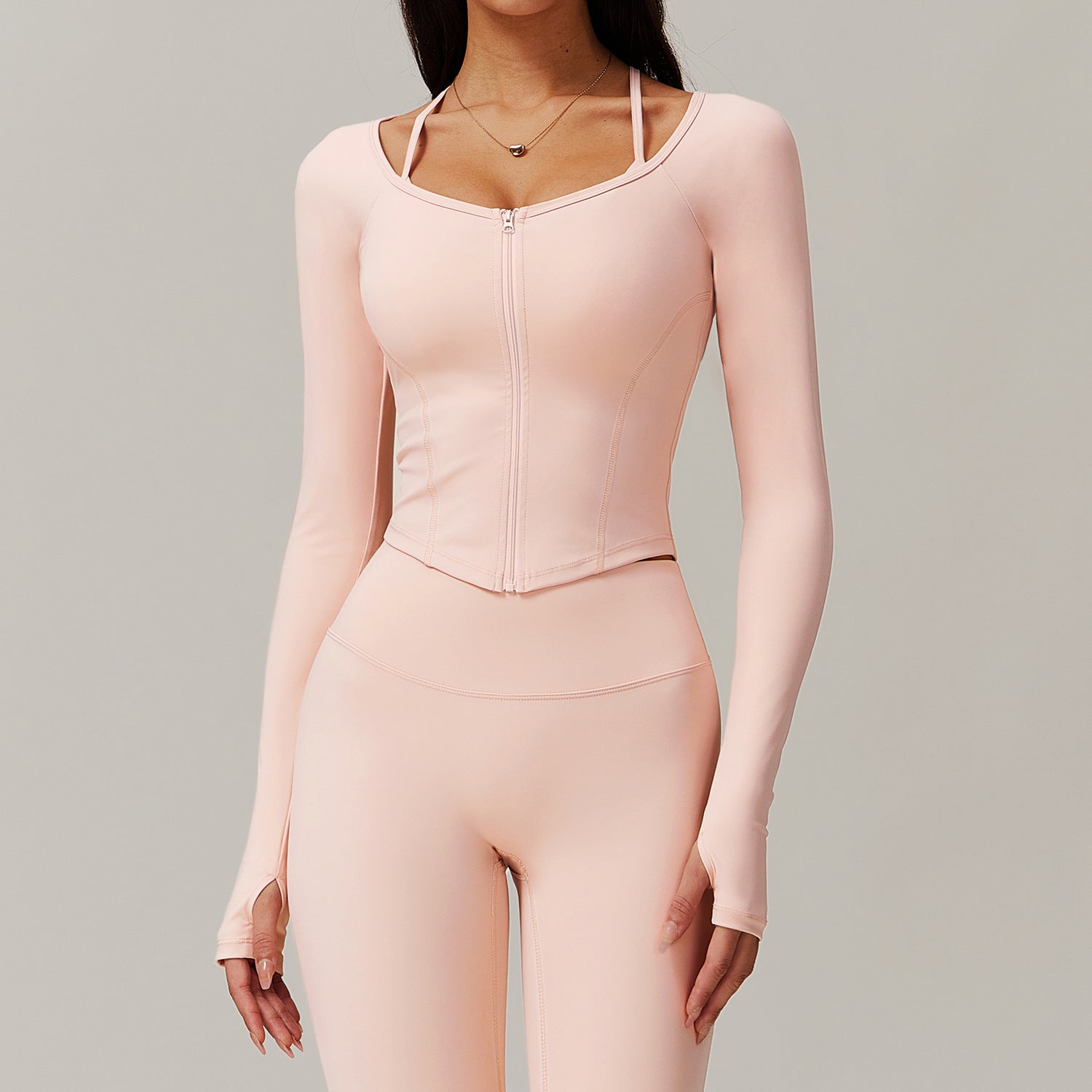 Pale pink long-sleeved athletic bodysuit and fitted leggings for comfortable yoga fashion
