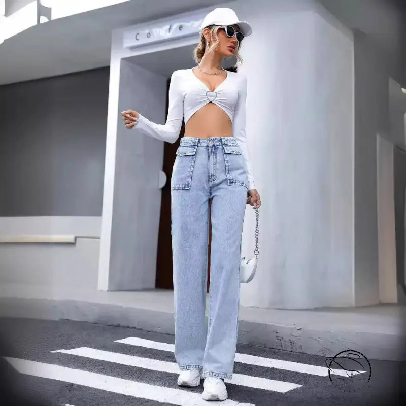 Woman in langry denim trousers, white crop top, cap, bag and sneakers