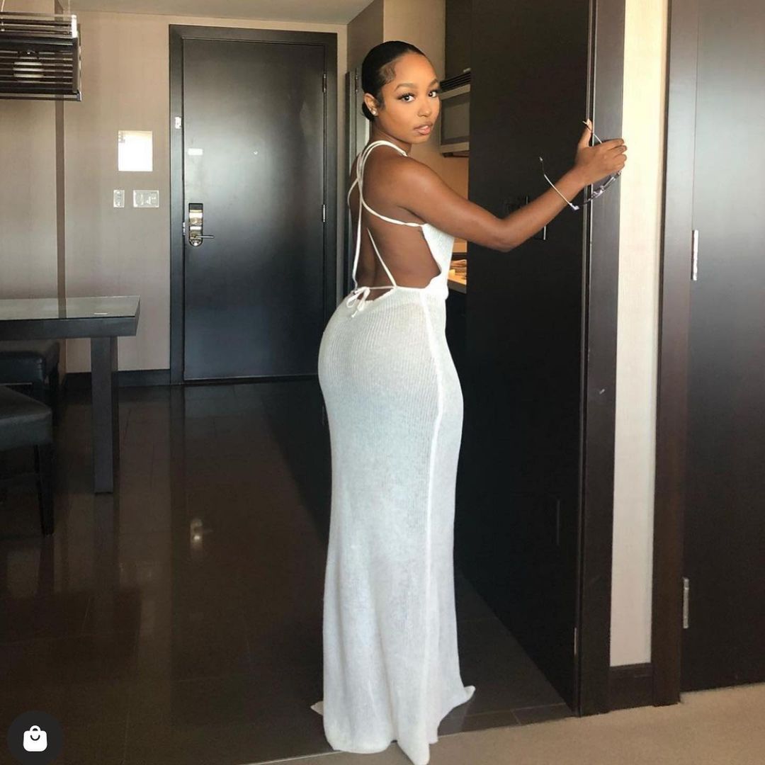 Woman wearing a white backless knitted beach maxi dress in light camel shade