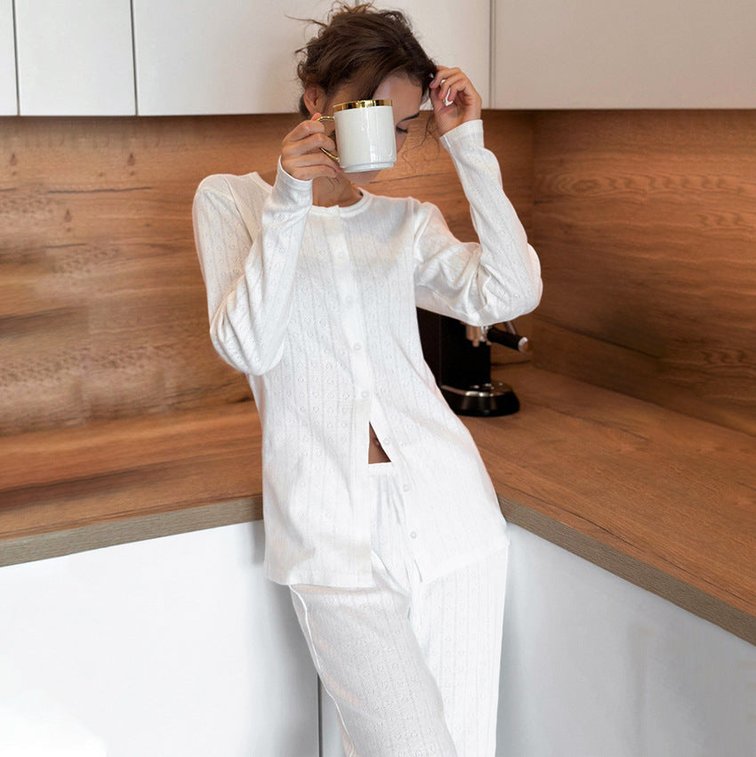 Woman in white knitted jacquard pajamas holding a white mug with a gold rim