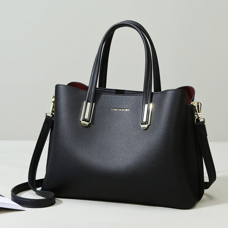 Elegant Soft Leather Bag in black, featuring handles and a removable shoulder strap for fashion