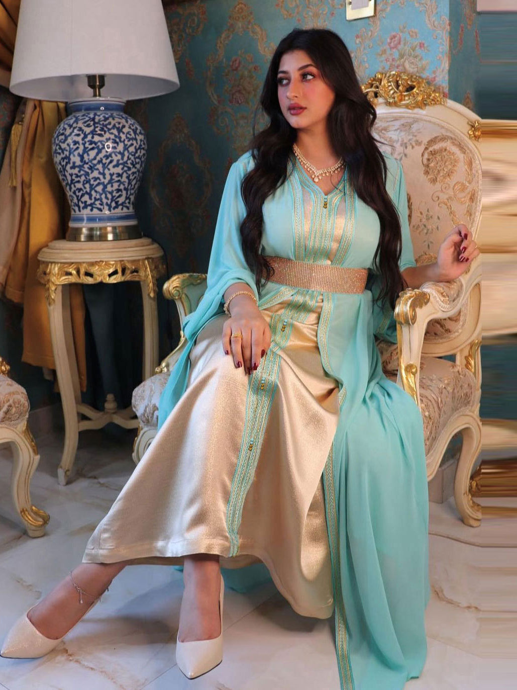 Elegant langry fashion two-piece dress in light blue silk kaftan with gold embroidery, white pants, beige heels