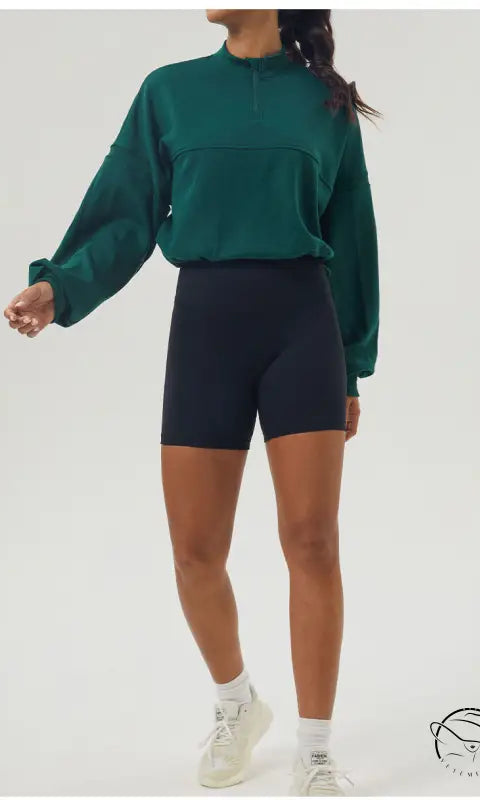 Woman in green autumn winter thickened sweater and black shorts