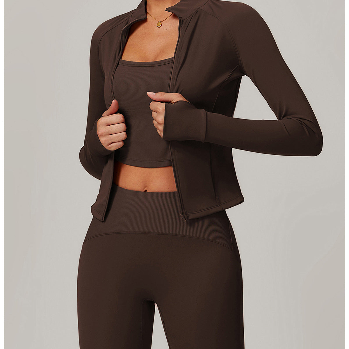 Brown langry three-piece athletic set featuring a cropped jacket, sports bra, and leggings