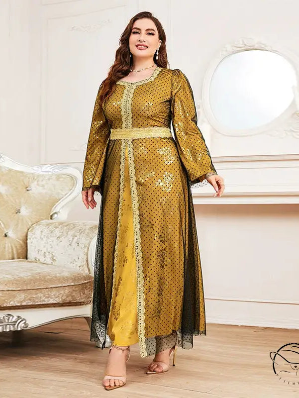 Woman in loose long sleeve A-line dress with golden-yellow fabric, black polka dots, and lace trim