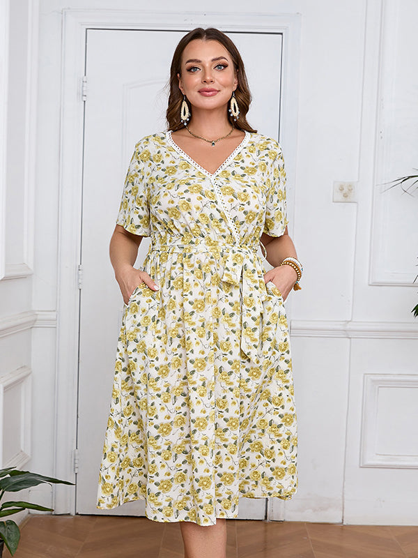 Woman wearing a boho lace floral dress with V-neck, short sleeves, and cinched waist