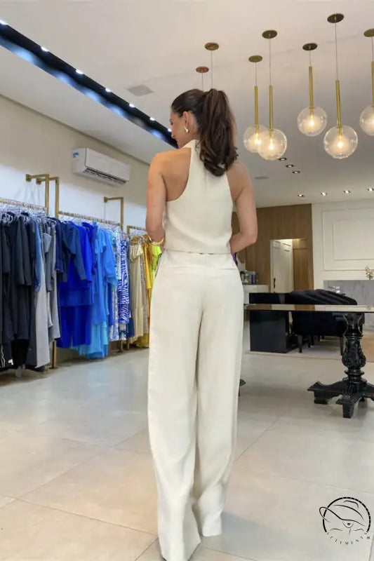 Elegant office jumpsuit set: woman’s white halter top and wide-leg pants