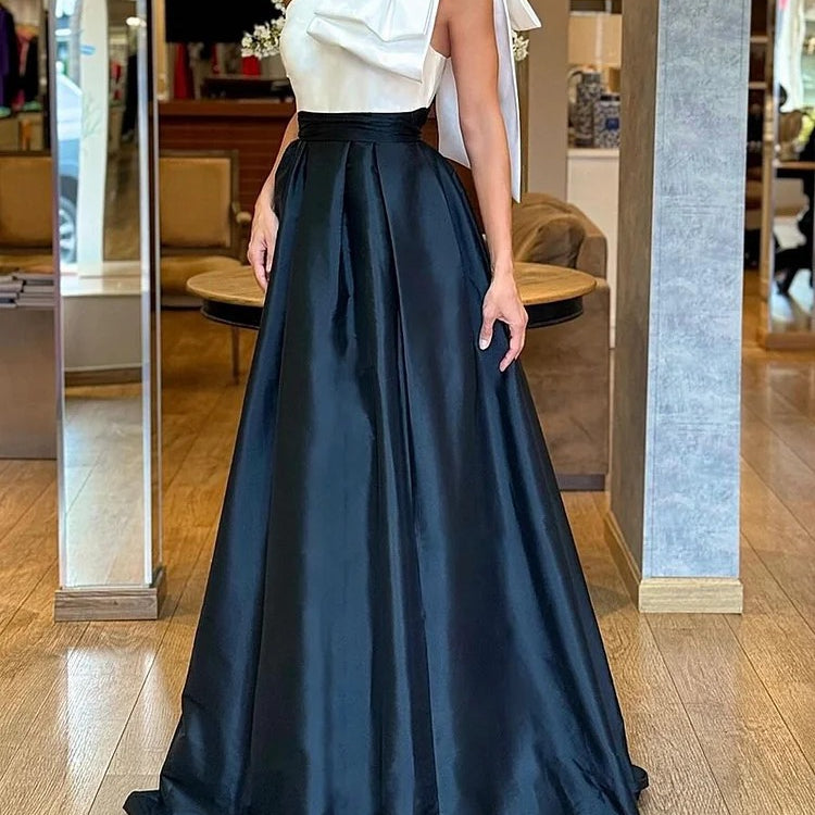 Elegant two-piece formal gown featuring a white top and black satin skirt in stylish fashion