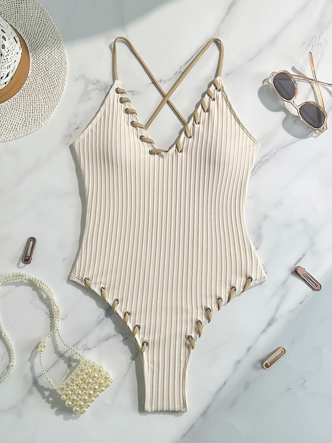 Cream-colored ribbed one-piece swimsuit with crisscross straps and scalloped edges in fashion