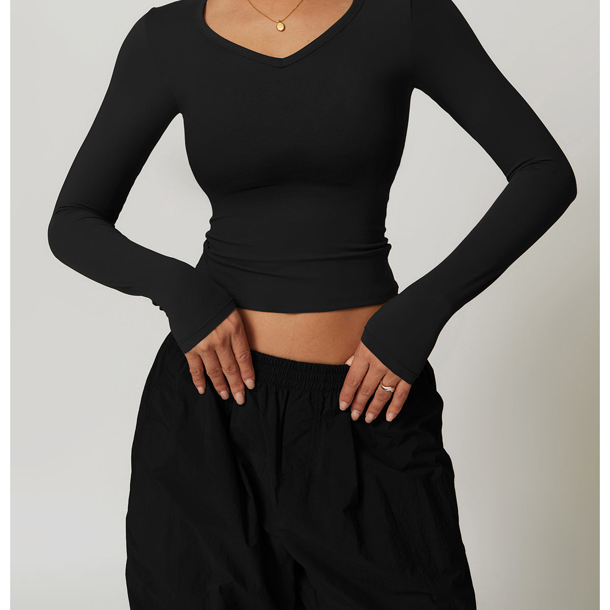 Black long-sleeved V-neck top with thumb holes and black pants from Winter Quick Drying Brushed Tight Yoga T shirt collection showcasing stylish ملابس and sporty langry fashion
