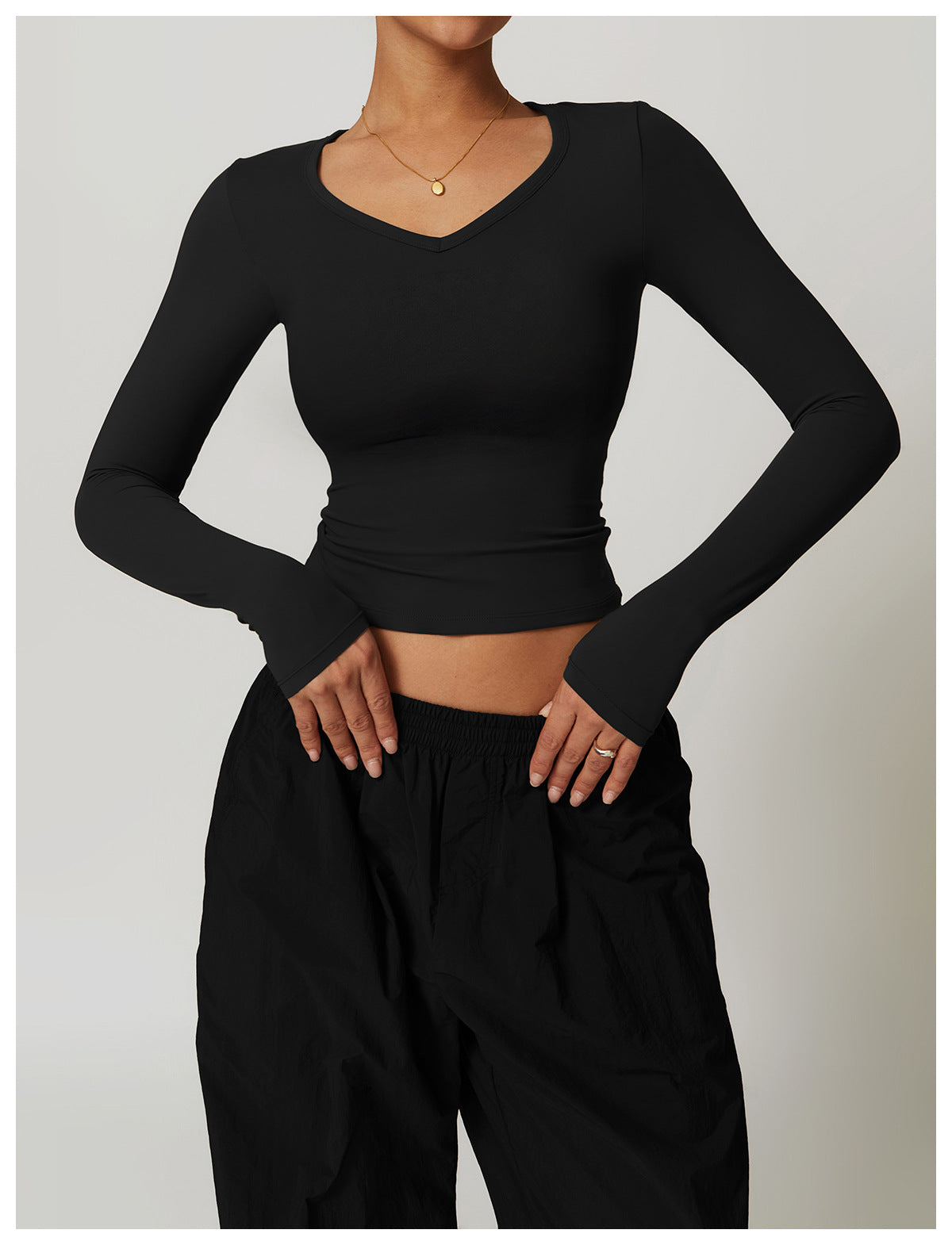 Black long-sleeved V-neck top with thumb holes and black pants from Winter Quick Drying Brushed Tight Yoga T shirt collection showcasing stylish ملابس and sporty langry fashion
