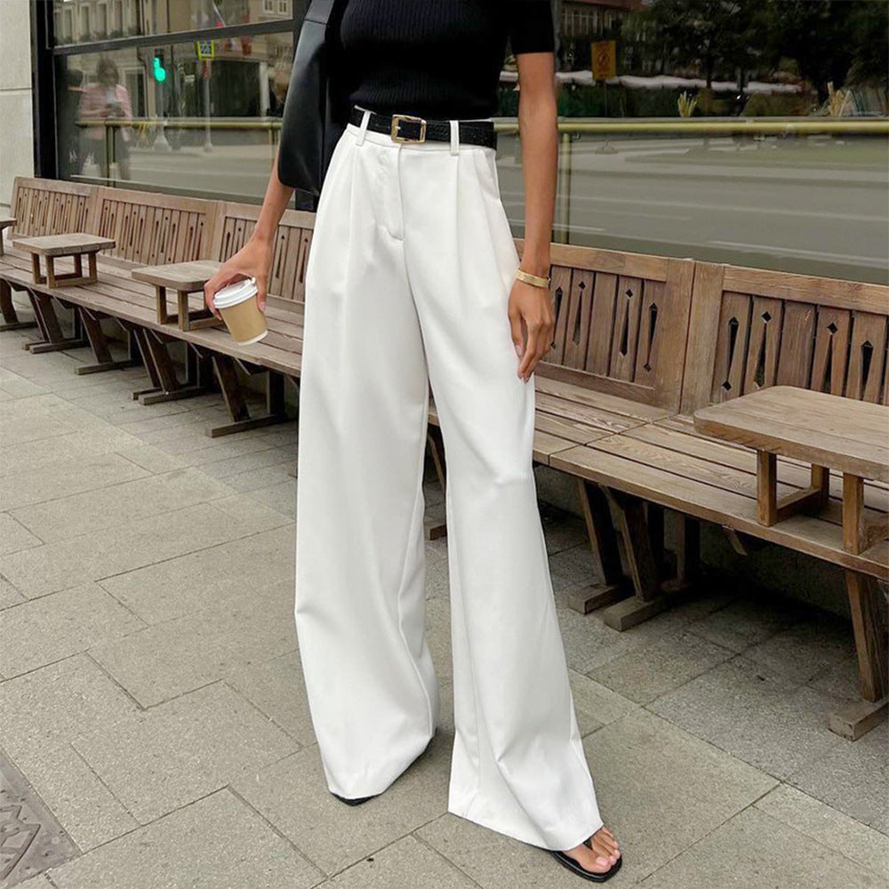 Woman in pure white office trousers holding coffee cup, stylish black top and sandals