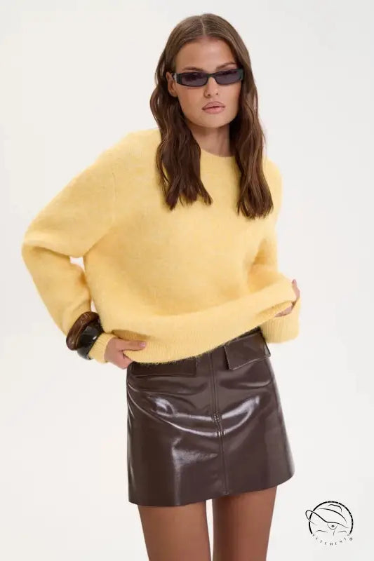 Winter loose long wool alpaca sweater in yellow with brown cuffs over leather skirt