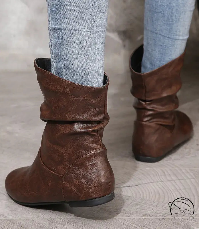 Low heel faux leather boots with jeans tucked in