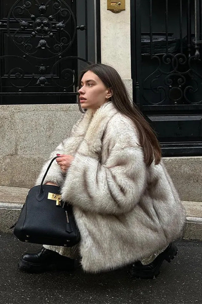 Fashionable warm faux fur coat with black leather handbag