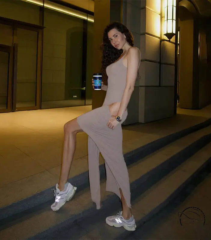 Woman in gorgeous langry maxi dress with high slits and white sneakers