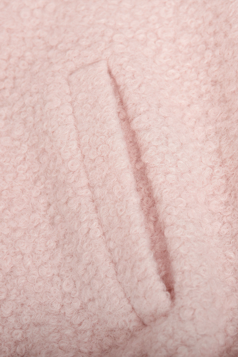 Pink short furry coat showcasing pink bouclé fabric with pocket detail
