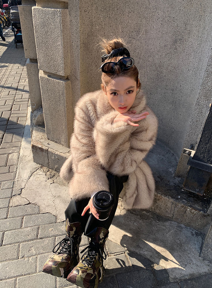 Beige faux fur Langry fashion jacket with black boots and bun