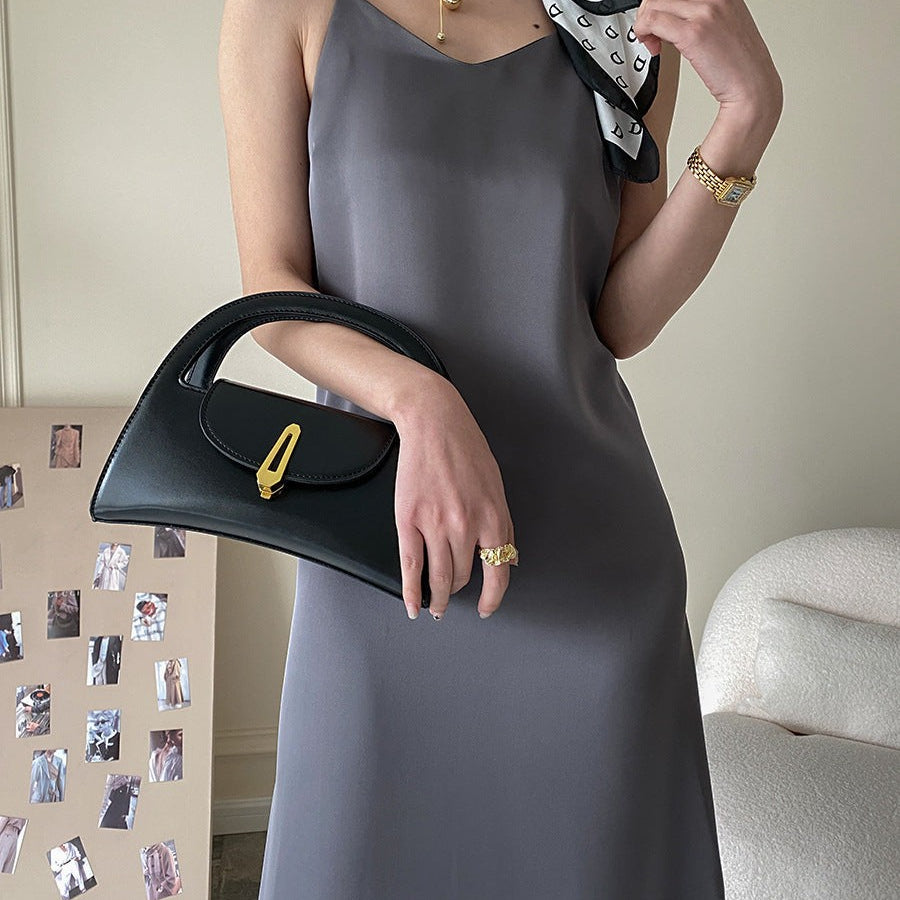 Obsidian black leather handbag with gold hardware on olive green acetate satin dress