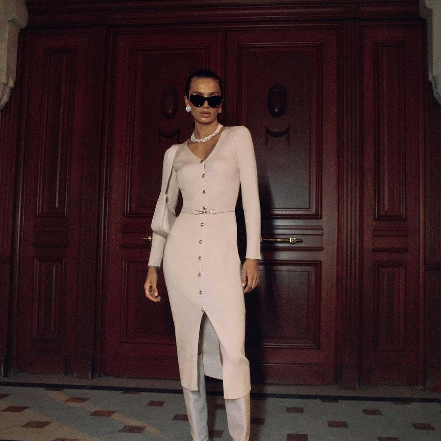 Woman in a beige long sleeve knitted dress showcasing elegant fashion and style