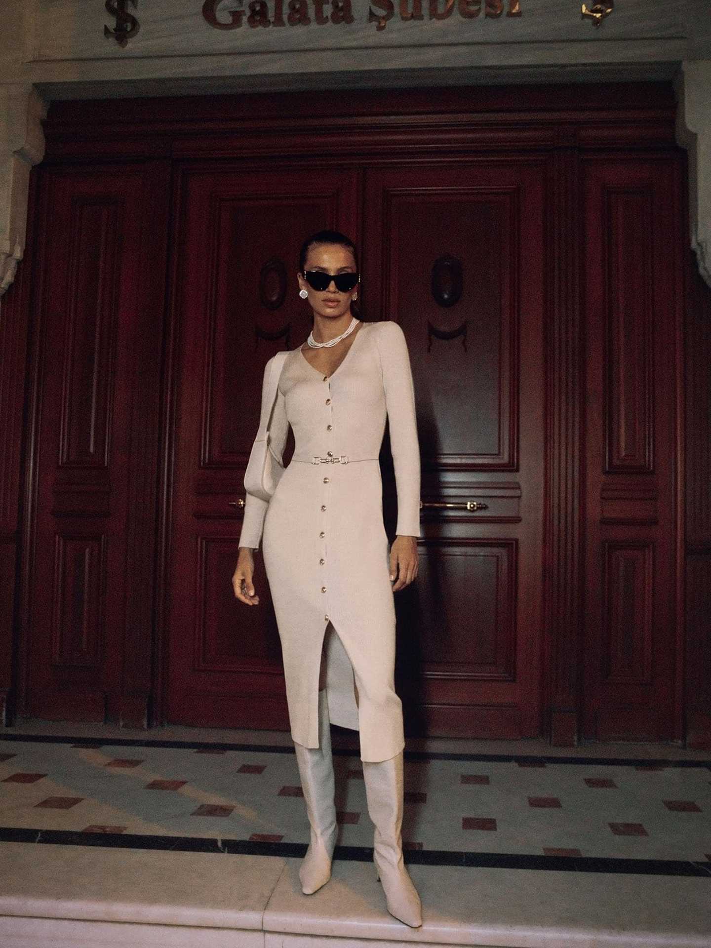 Woman in a beige long sleeve knitted dress showcasing elegant fashion and style