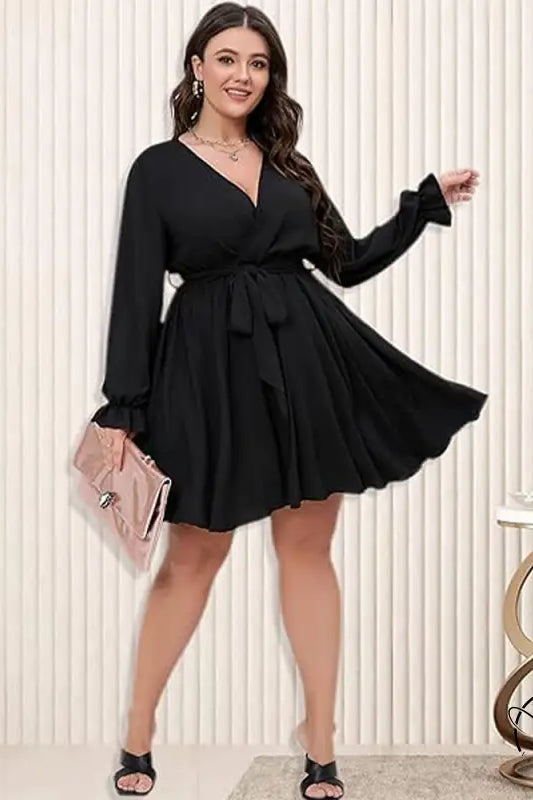 Woman in black winter office midi dress with V-neck, tie-waist, holding pink clutch