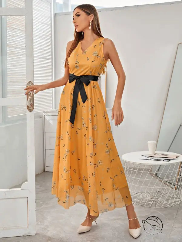 Elegant long langry fashion dress in flowing yellow floral with black satin bow belt