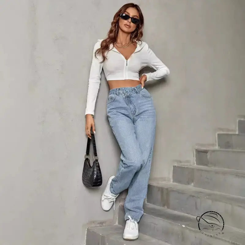 Woman in white cropped hoodie, elastic slimming denim trousers, black bag