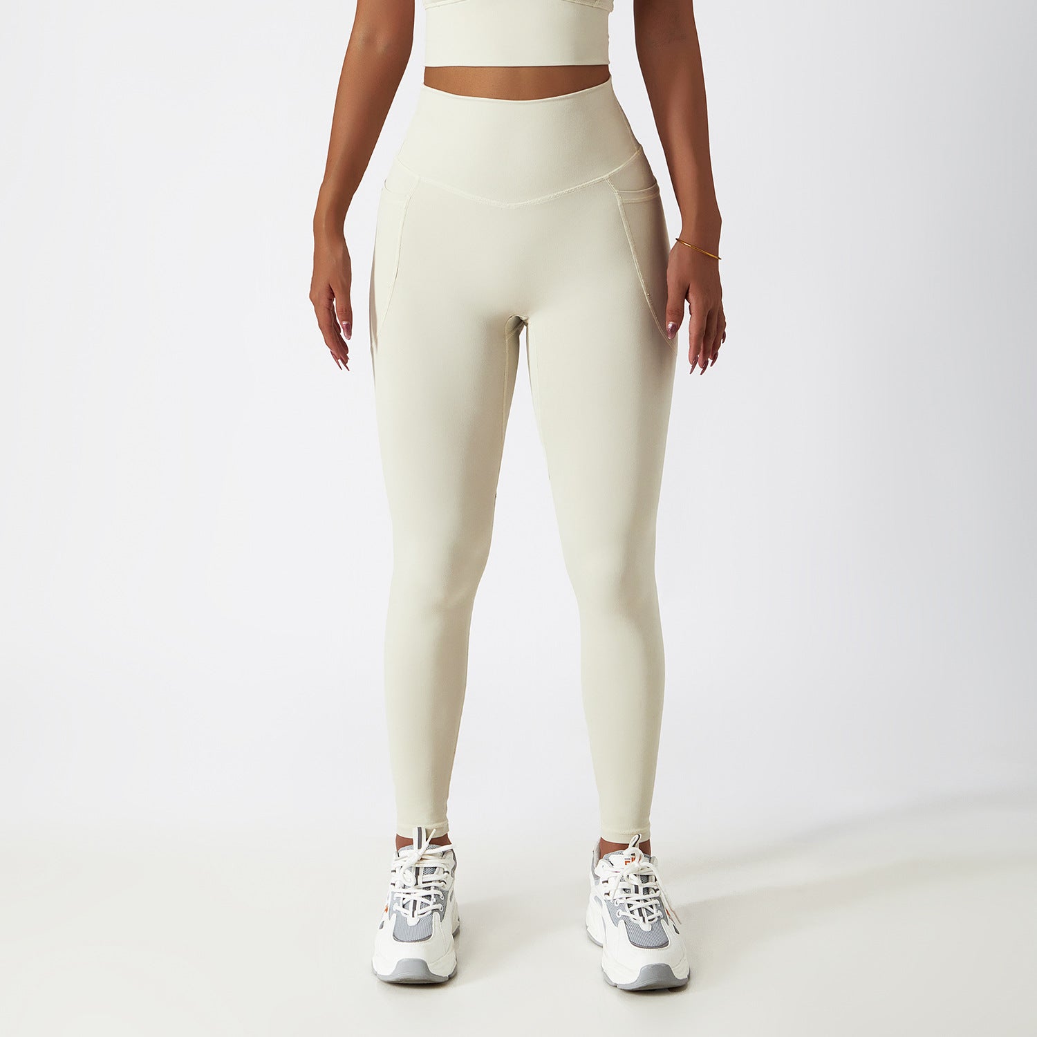 Cream-colored high-waisted athletic leggings with white sneakers for fashionable yoga wear