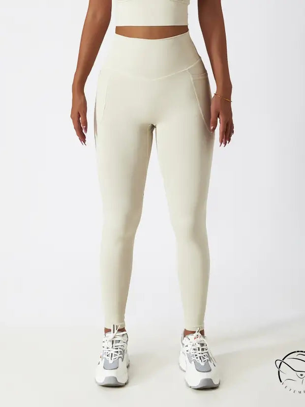Cream-colored high-waisted yoga pants with white sneakers for langry fashion