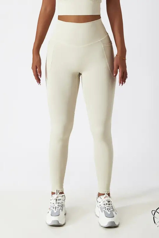 Cream-colored high-waisted yoga pants with white sneakers for langry fashion