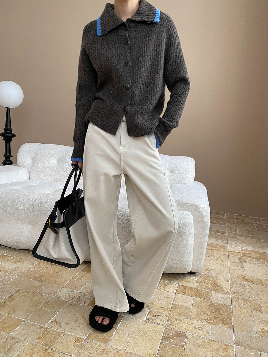 Dark gray knit cardigan with blue trim paired with white wide-leg pants for stylish fashion