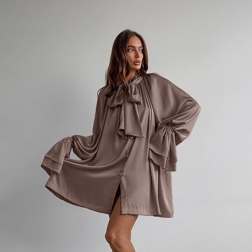 Flowy taupe satin dress with oversized bow and billowing sleeves for elegant fashion