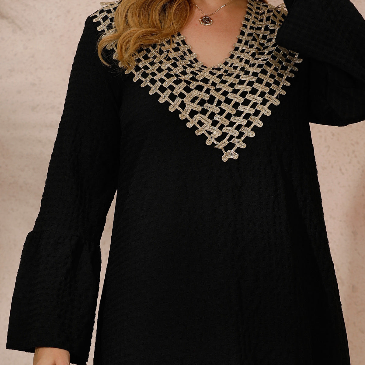 Black long-sleeved robe dress with flared sleeves and intricate gold and white embroidery