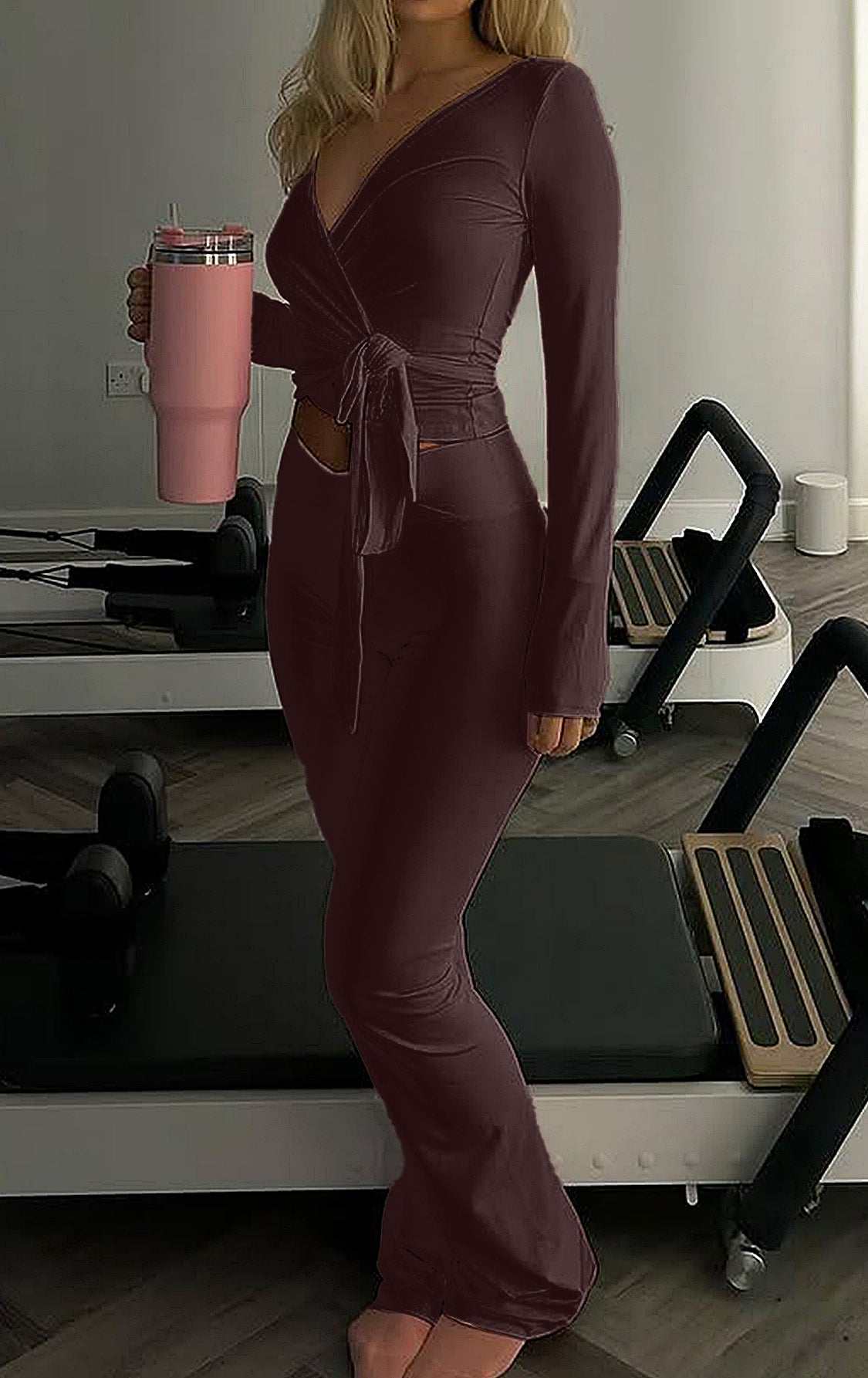 Woman in form-fitting maroon langry fashion wrap dress with cutout detail