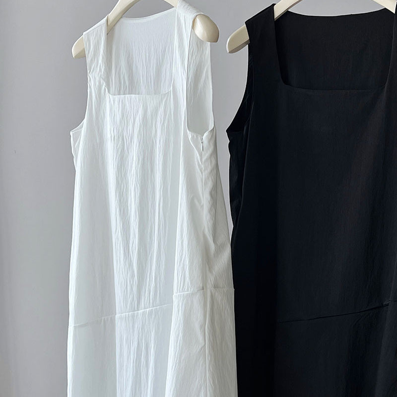Two elegant Korean style dresses, one white and one black, hanging on hangers