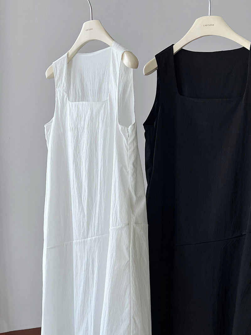 Two elegant Korean style dresses, one white and one black, hanging on hangers