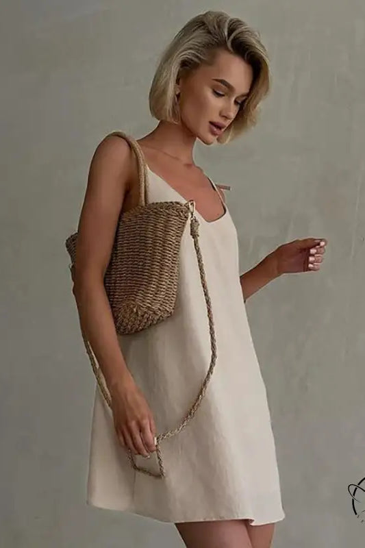 Woman in casual backless cotton home wear slip dress with straw bag