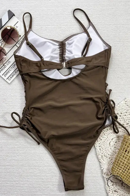 Brown cutout strap one-piece swimsuit with side ties and white details