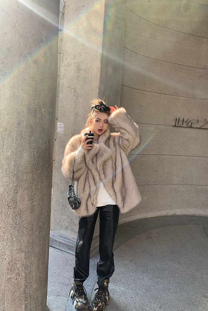 Beige faux fur oversized coat with leather accents and floral headband