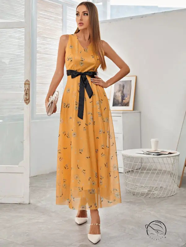 Elegant long dress: flowing yellow floral maxi with black satin bow belt