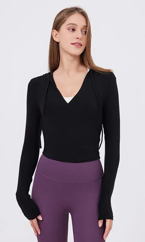 Slim fit slimming black long-sleeved hoodie with V-neck and side ties over white top