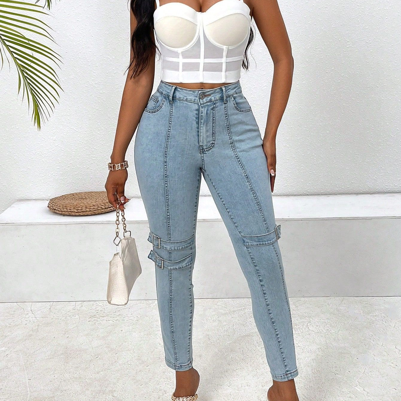 High elastic skinny jeans featuring light blue fabric and embellished knee details