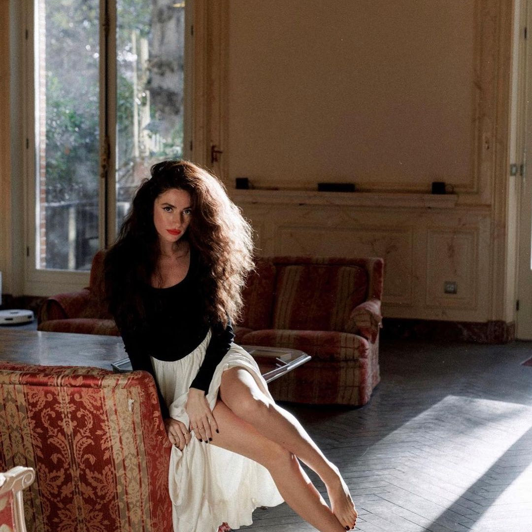 Woman in Elegant Hepburn Dress showcasing langry fashion on ornate fabric surface