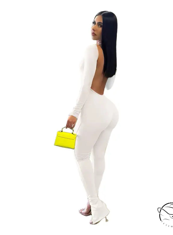 Elegant backless slit jumpsuit with woman in white and yellow purse