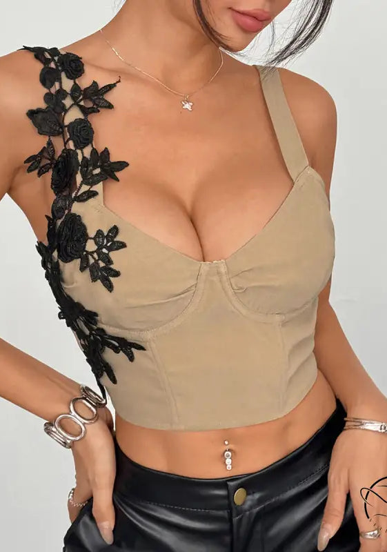 Beige lace corset crop top with black floral applique and pocket detail