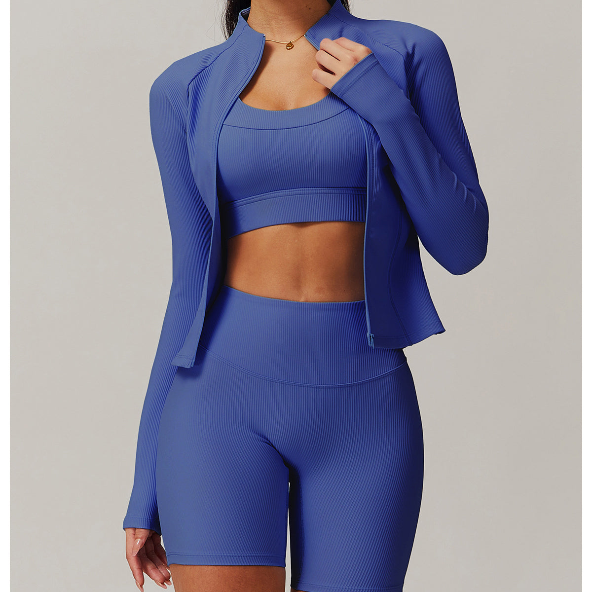 Royal blue three-piece athletic set featuring a zip-up jacket, sports bra, and fitted shorts